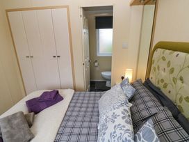 A bedroom with a bed and wardrobe at Reef Retreat in Little Haven