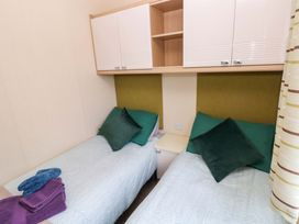 A bedroom with two beds and storage space at Reef Retreat in Little Haven