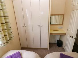 A bedroom with a wardrobe and vanity table at Reef Retreat in Little Haven