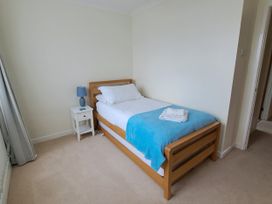 A bedroom with a single bed and bedside table at 30 Long Shepherds Drive, Newton near The Mumbles