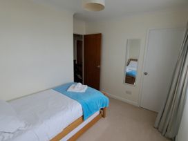 A bedroom with a single bed and a mirror at 30 Long Shepherds Drive in Newton near The Mumbles