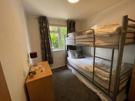 A bedroom with a bunk bed and dresser at Treetops Beech Hill 13, Fallbarrow Park near Bowness-On-Windermere