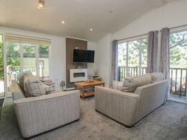 A living room with sofas and a television at Treetops, Beech Hill 13, Fallbarrow Park near Bowness-On-Windermere