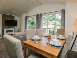 A dining room with a table set for meals at Treetops, Beech Hill 13, Fallbarrow Park near Bowness-On-Windermere