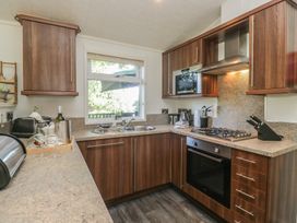 A kitchen with cabinets and appliances at Treetops, Beech Hill 13, Fallbarrow Park near Bowness-On-Windermere