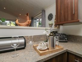 A kitchen with a wine bottle and glasses on a tray at Treetops, Beech Hill 13, Fallbarrow Park near Bowness-On-Windermere