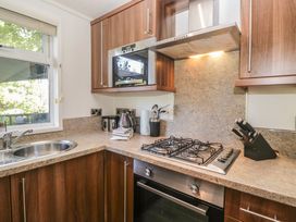 A kitchen with a sink, gas stove, and microwave at Treetops Beech Hill 13 ,Fallbarrow Park near Bowness-On-Windermere