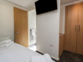 A bedroom with a television and wardrobe at Treetops Beech Hill 13 ,Fallbarrow Park near Bowness-On-Windermere
