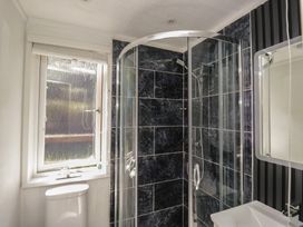 A bathroom with a shower, toilet, sink, and window at Treetops Beech Hill 13 ,Fallbarrow Park near Bowness-On-Windermere