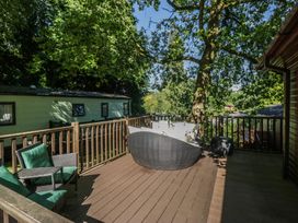 A decking area with seating and trees at Treetops Beech Hill 13, Fallbarrow Park near Bowness-On-Windermere