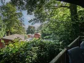 A view of wooden cabins and greenery at Treetops, Beech Hill 13, Fallbarrow Park near Bowness-On-Windermere