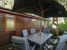 An outdoor seating area with table and chairs at Treetops Beech Hill 13, Fallbarrow Park near Bowness-On-Windermere