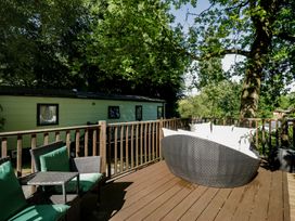 An outdoor area with a sofa, chair, and table at Treetops Beech Hill 13, Fallbarrow Park near Bowness-On-Windermere