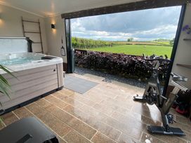 An indoor space with a hot tub and spinning exercise bike opening to a view of green fields at Ashlea in Launceston