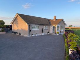 A single story house with a paved driveway and plants along the side at Ashlea in Launceston