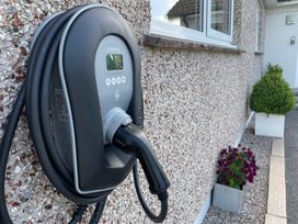 An electric vehicle charger mounted on a wall in an outdoor area at Ashlea in Launceston
