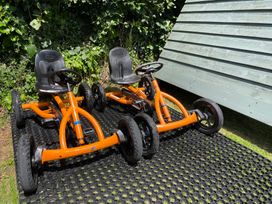 Two orange go-karts on a mat in a garden at Ashlea Launceston