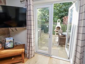 A living room with patio doors leading to a garden at Crispin in Lucker