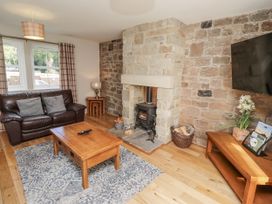 A living room with a stone fireplace and sofa at Crispin in Lucker