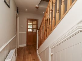 A hallway with a staircase and a door at Crispin in Lucker