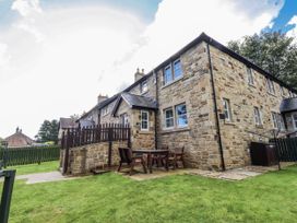 An outdoor area with a stone house and furniture at Crispin in Lucker