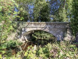 A bridge over water surrounded by trees at Crispin in Lucker
