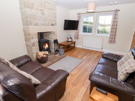 A living room with a fireplace and sofas at Pippin in Lucker