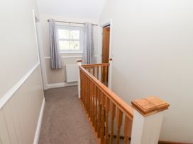 A hallway with a stair railing and window at Pippin in Lucker