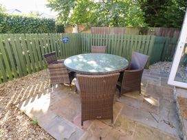 A patio area with a round table and chairs at Pippin in Lucker