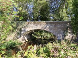 A stone bridge over a stream surrounded by trees and vegetation at Pippin in Lucker