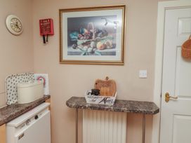 A kitchen with a clock, baking dish, and welcome sign at Ahoy in Seahouses