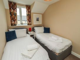A bedroom with two beds and a window at Ahoy in Seahouses