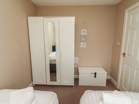 A bedroom with a wardrobe and a blanket box at Ahoy in Seahouses