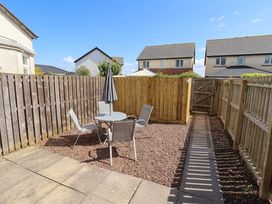 A garden with a table and chairs at Ahoy in Seahouses