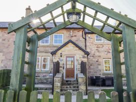 An outdoor view of a house with an archway and seating area at Bramley in Lucker