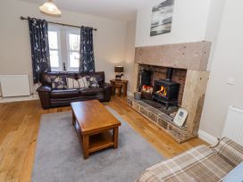 A living room with a fireplace and sofa at Bramley in Lucker