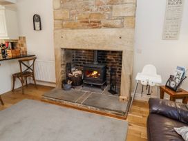 A living room with a fireplace and high chair at Bramley in Lucker