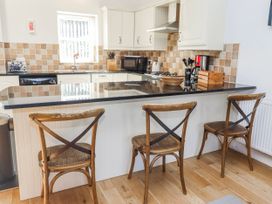 A kitchen with a countertop and bar stools at Bramley in Lucker