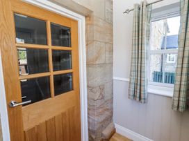 A hallway with a wooden door and window at Bramley, Lucker