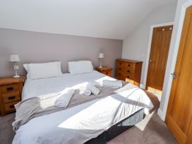 A bedroom with a double bed and wooden furniture at Bramley in Lucker