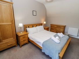 A bedroom with a bed and wooden furniture at Bramley in Lucker