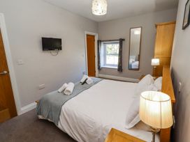 A bedroom with a bed, television, and window at Bramley in Lucker