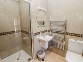 A bathroom with a shower, sink, mirror, and toilet at Bramley in Lucker
