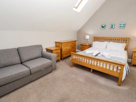 A bedroom with a bed and a sofa at Bramley in Lucker