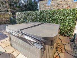 A hot tub in a garden area at Bramley in Lucker