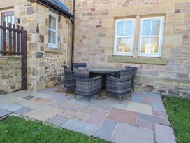 A patio with a table and chairs at Bramley in Lucker