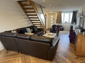A living room with a sofa and staircases at Farne Cottage in Beadnell