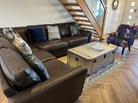 A living room with a sofa and a coffee table at Farne Cottage Beadnell