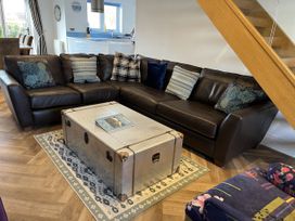 A living room with a sofa and a coffee table at Farne Cottage in Beadnell