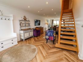 A living room with staircase and sofa at Farne Cottage Beadnell